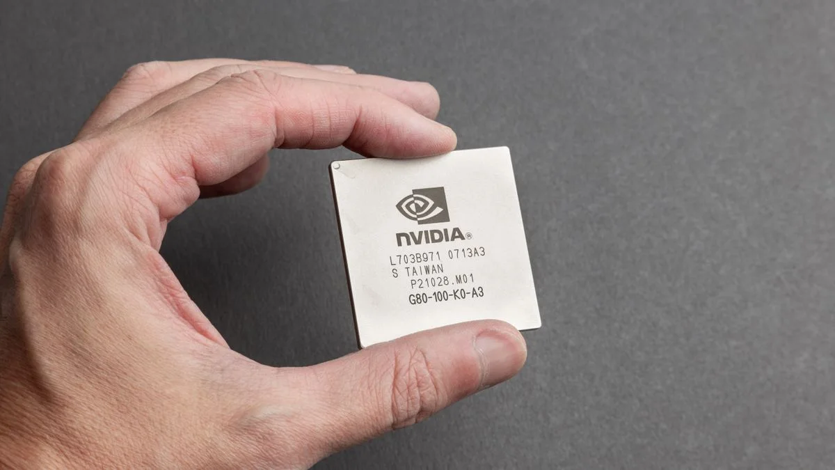 Close-up of a person holding an NVIDIA chip against a gray background, illustrating the AI model speed race. Photo: Stas Knop / Pexels.