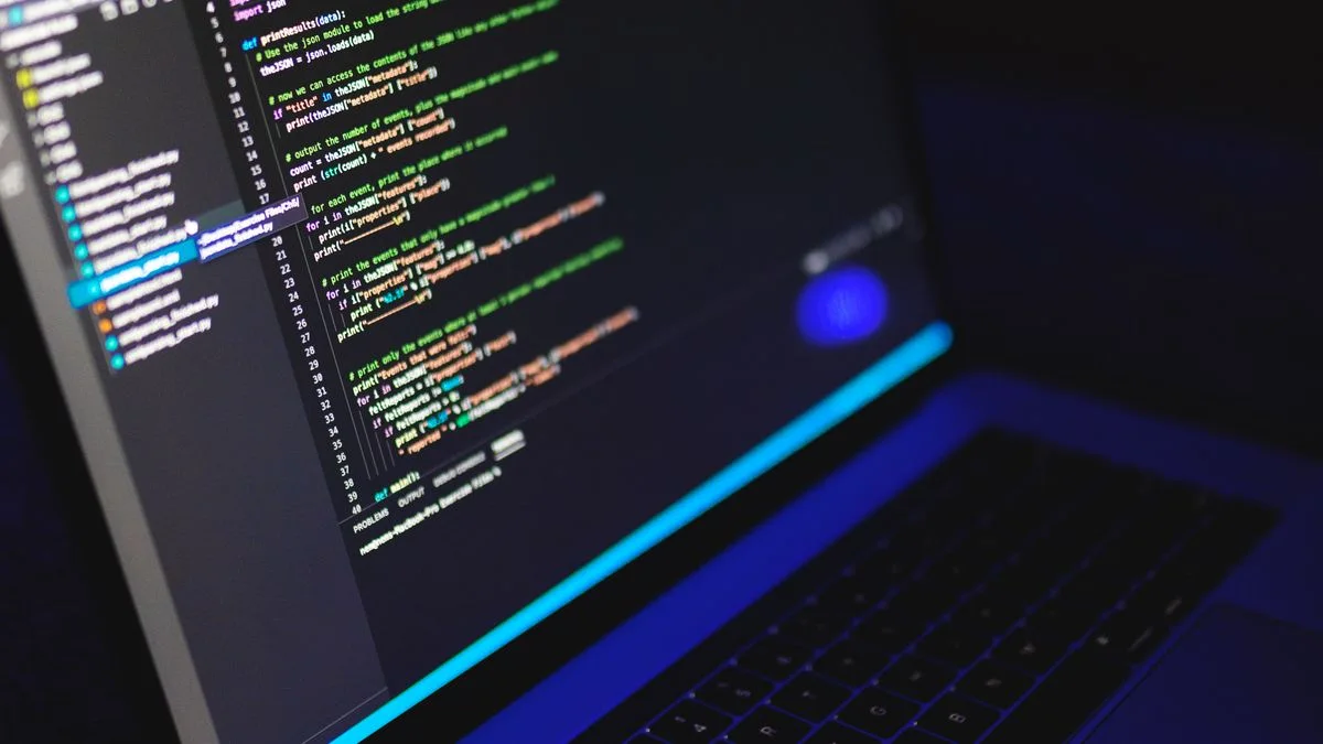 Laptop screen displaying code in a dark room, illustrating local AI coding with Recursive's Flint model